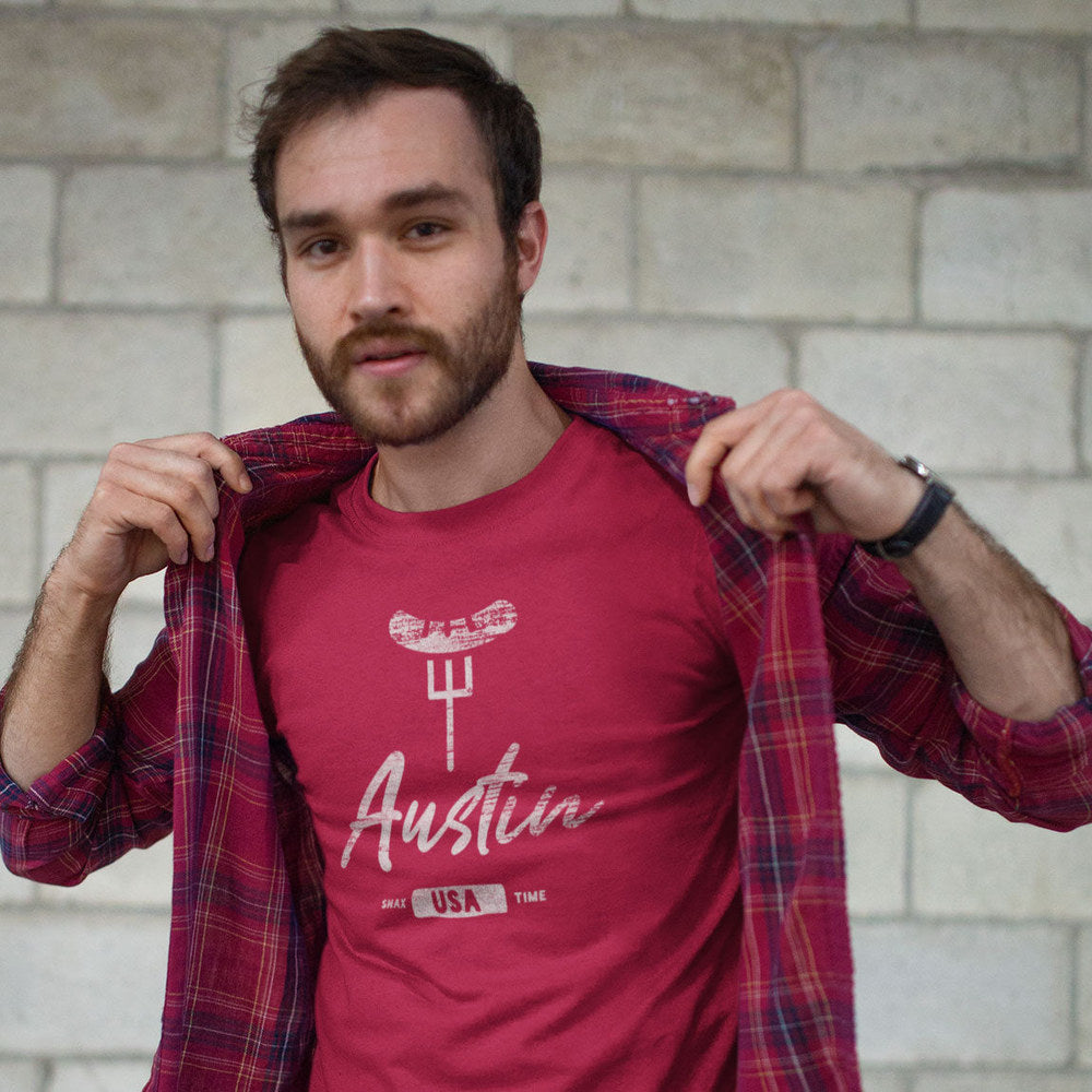 Bearded man opening a plaid flannel over the red "Austin" BBQ t-shirt