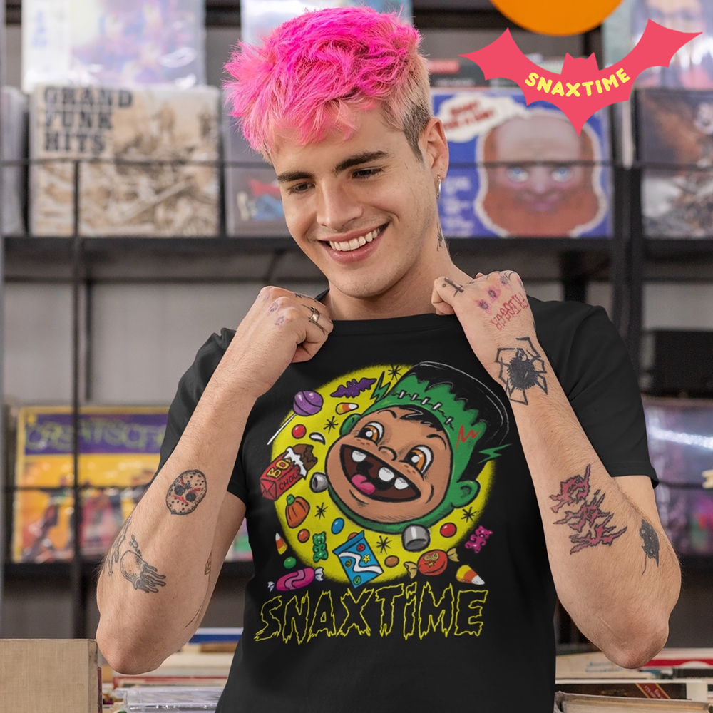 Person with pink hair in a record store wearing a black Frankenstein monster and Halloween candy t-shirt